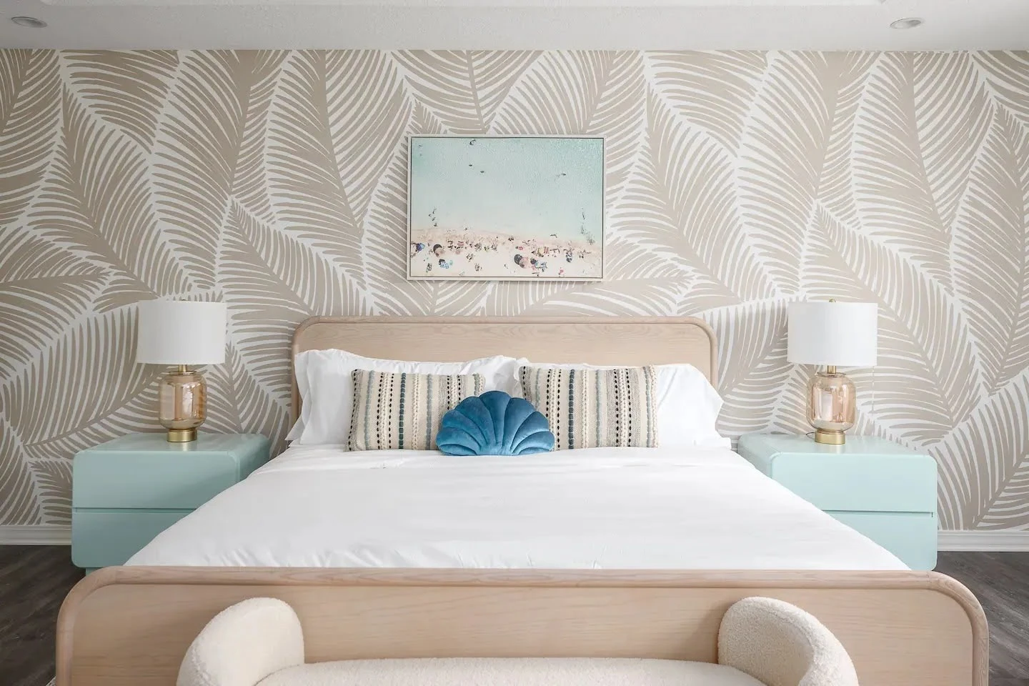 Airbnb bedroom with a pale blue bed, neutral rug, and symmetrical lamps