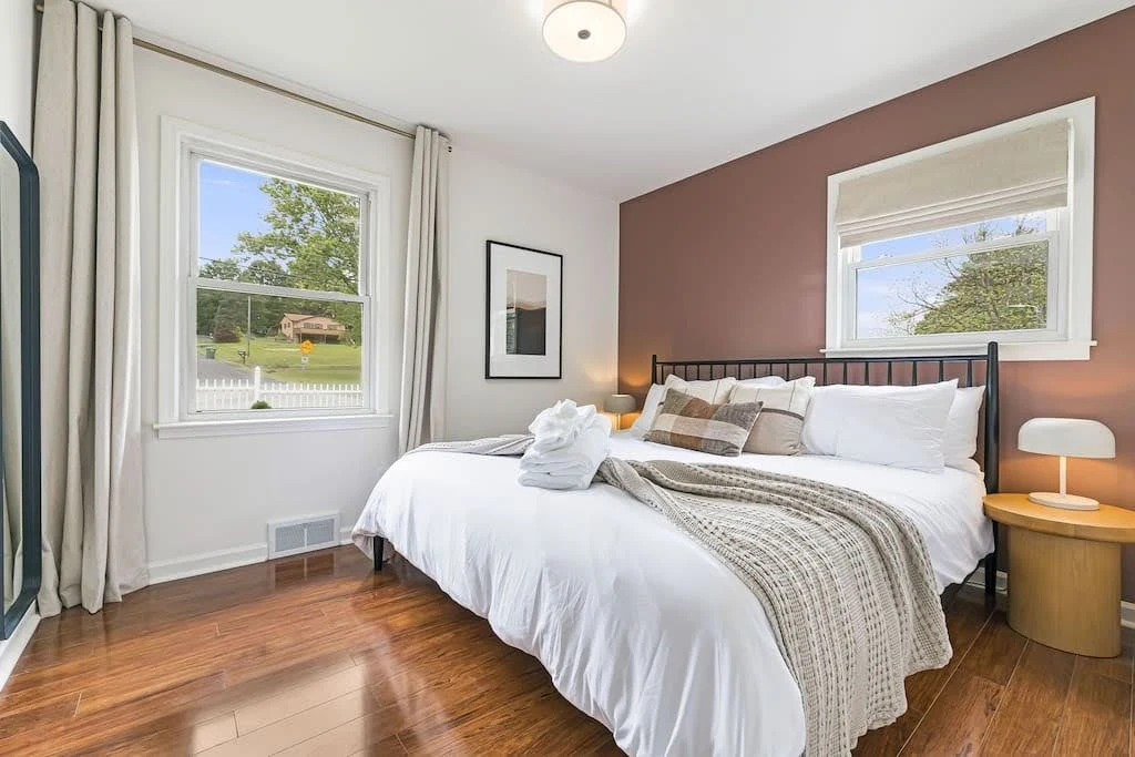 Airbnb bedroom with landscape views, earthy colors, and a wood-framed bed